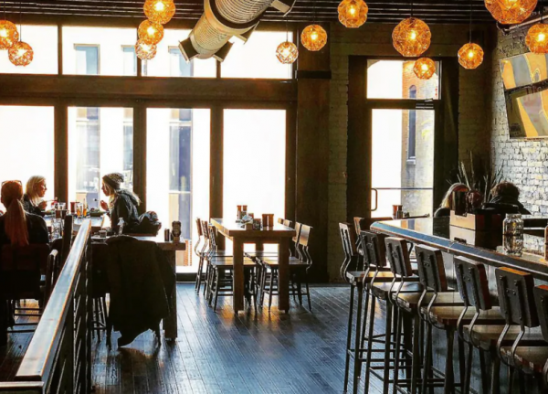 Cafe dengan tema urban industrial yang unik, dengan dinding bata ekspos dan aksen logam